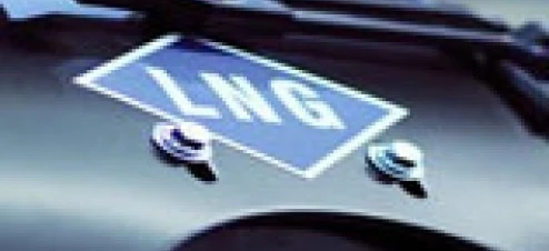 A classic car with a logo on the hood being measured using a measuring instrument. It is a sports car kit in progress.